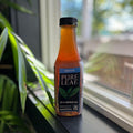 Bottle of Pure Leaf tea on a windowsill with plants in the background