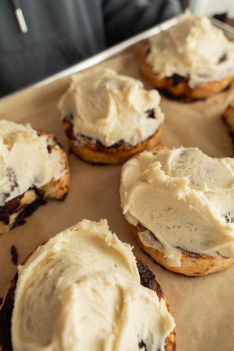 Baked goods with cream cheese frosting on a baking sheet
