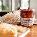 Jar of Bonne Maman Apricot Preserves on a table with a pastry