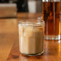 Glass of iced coffee on a wooden table with a blurred background
