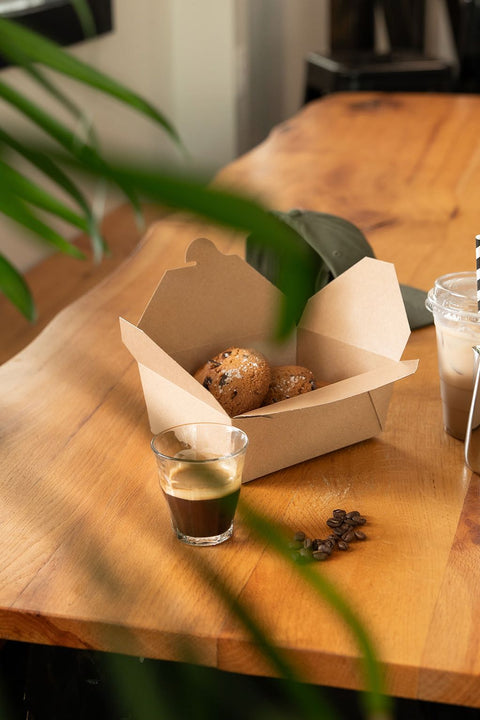 Bakery items including pastries and a glass of iced coffee on a wooden table.