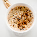 Frothy hot chocolate in a white mug on white table