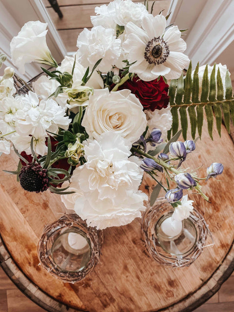 Floral arrangement with white and red flowers on a wooden table