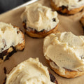 Baked goods with cream cheese frosting on a baking sheet