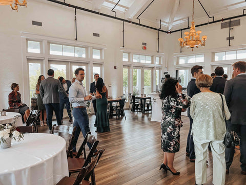 People socializing in a well-lit room with tables and chairs.
