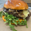 Hamburger with arugula, onions, and cheese on a bun